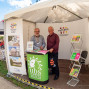 Zwei Männer stehen in einem weißen Messezelt an einem Informationsstand von viaTEATRI und dem Uckermärkischen Bühnen Schwedt. Um sie herum sind Banner, Plakate und Broschürenständer zu sehen, während draußen weitere Stände und Besucher eines Festes erkennbar sind.